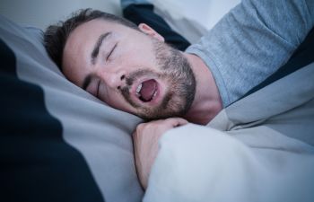 Snoring man sleeping with open mouth.